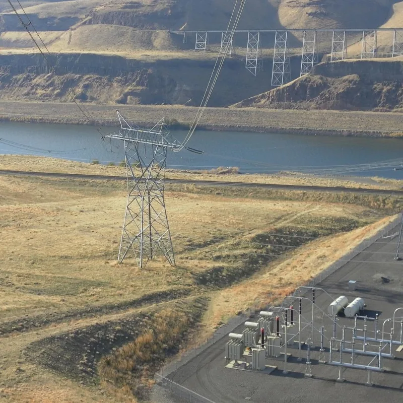 Aerial view of a 500 kV transmission tower and substation along the Columbia River