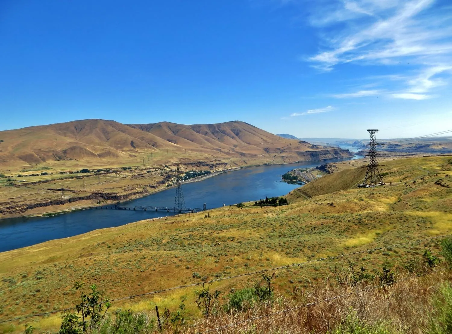 Transmission towers and the Columbia River winding through rolling hills